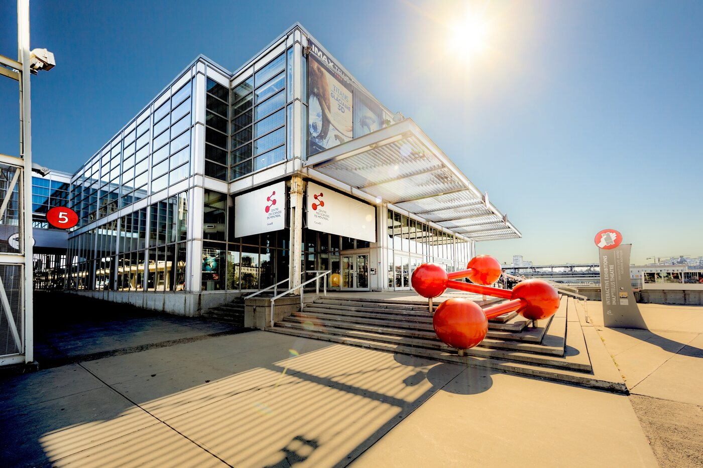 The all-glass Montreal Science Centre on King Edward Pier in the Old Port, with its red molecule sculpture out front.